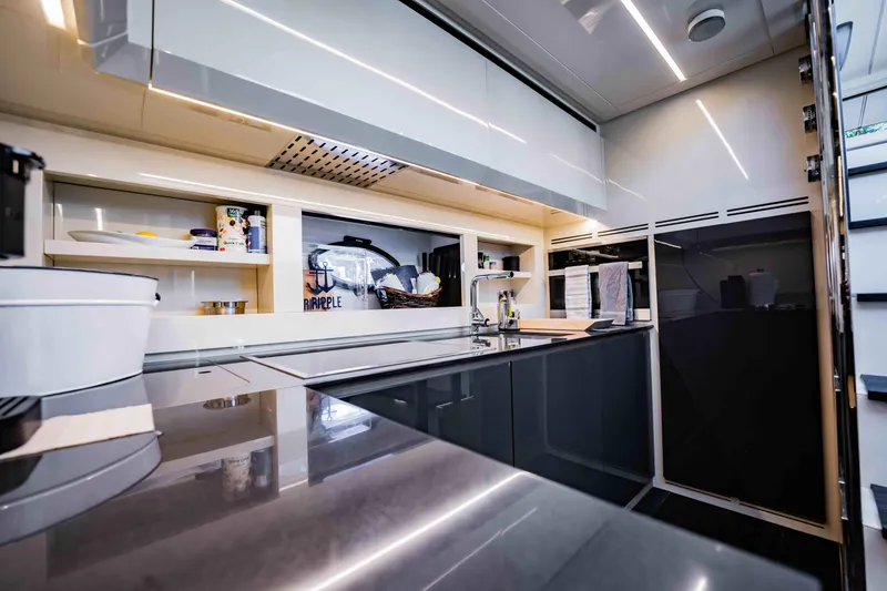 Slide: The Image of Modern kitchen interior on a 2017 Pershing 70 yacht, featuring sleek cabinetry and appliances. - 25