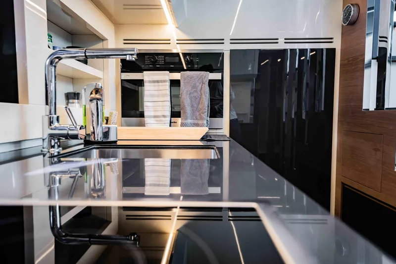 Slide: The Image of Modern kitchen interior on a 2017 Pershing 70 yacht, featuring sleek countertops and appliances. - 26