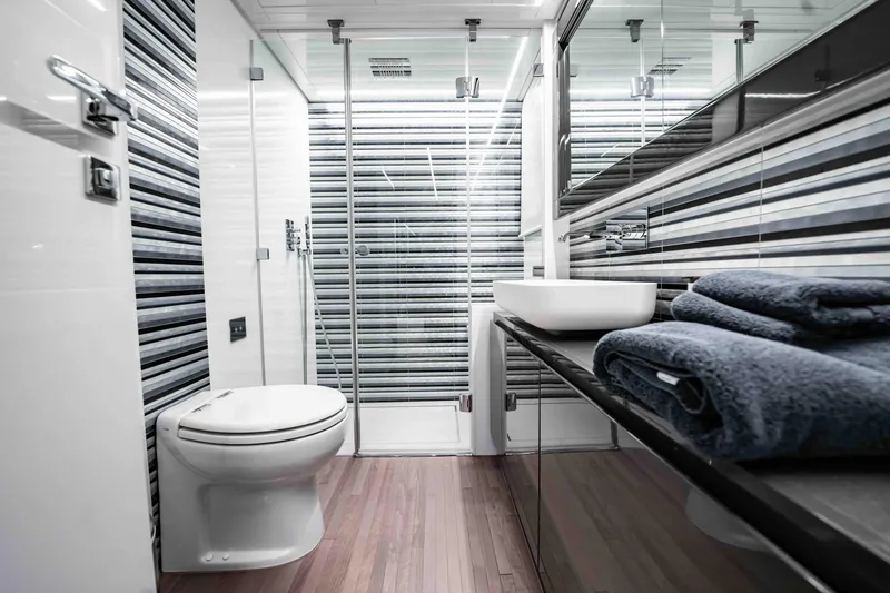 Slide: The Image of Luxurious bathroom in a 2017 Pershing 70 yacht, featuring modern design and striped walls. - 32