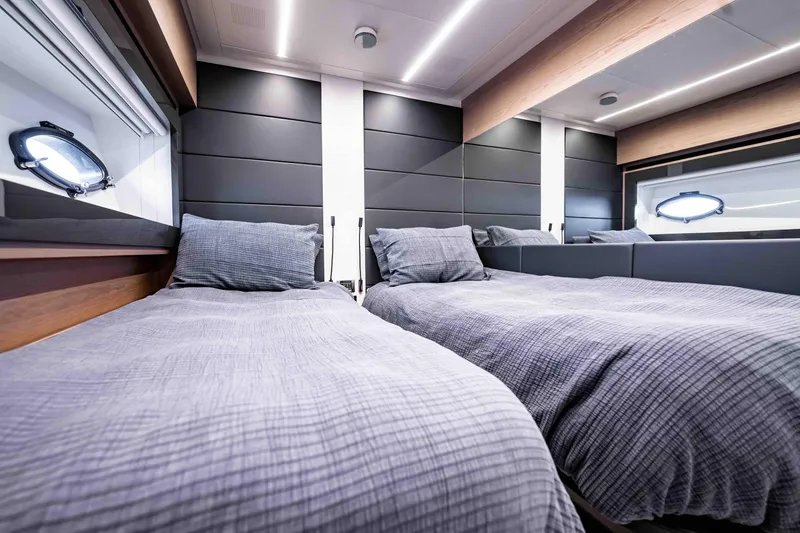 Slide: The Image of Luxurious twin bedroom interior on a 2017 Pershing 70 yacht, featuring modern design and porthole windows. - 39