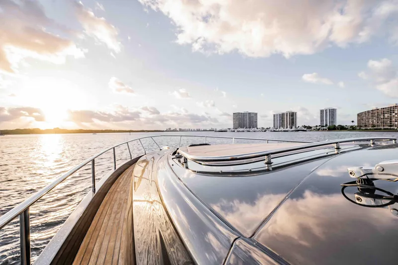 Slide: The Image of Luxurious 2017 Pershing 70 yacht cruising at sunset with city skyline in background. - 43