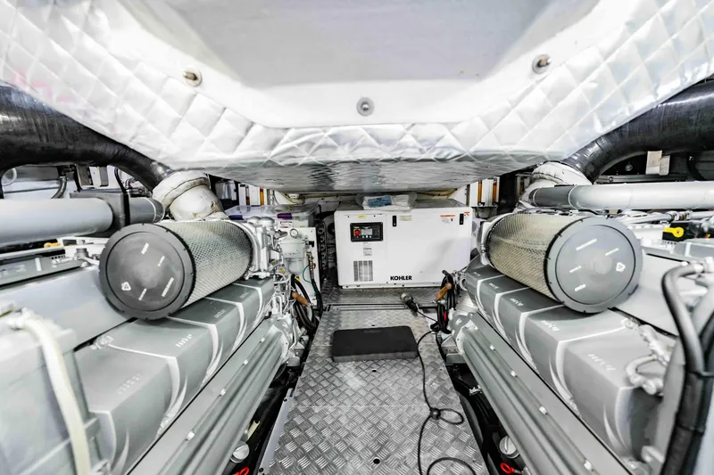 Slide: The Image of Engine room of a 2017 Pershing 70 yacht, featuring dual engines and a Kohler generator. - 44