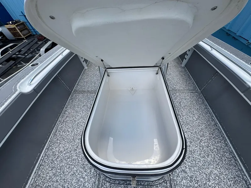 Slide: The Image of 2022 Twin Vee 310 CC GF Classic boat storage compartment open, showcasing interior space. - 6