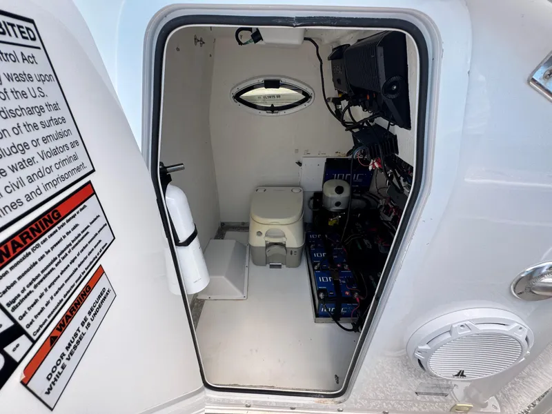 Slide: The Image of 2022 Twin Vee 310 CC GF Classic boat interior with toilet and equipment storage. - 7