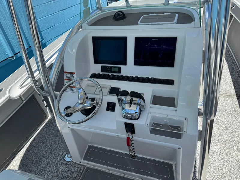 Slide: The Image of 2022 Twin Vee 310 CC GF Classic boat console with steering wheel and navigation screens. - 8