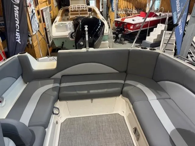 Slide: The Image of 2023 NauticStar 223 DC boat interior with gray seating in showroom. - 10