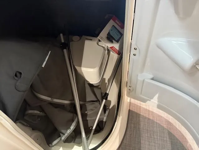 Slide: The Image of Storage compartment in 2023 NauticStar 223 DC boat, containing folded items and accessories. - 13