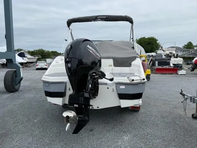 Slide: The Image of 2023 NauticStar 223 DC boat with Mercury outboard motor, parked on gravel lot. - 4