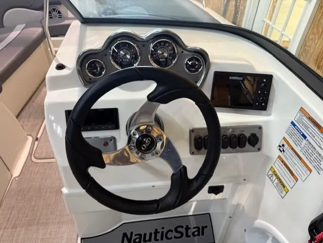 Slide: The Image of 2023 NauticStar 223 DC boat dashboard with steering wheel and control panel. - 7