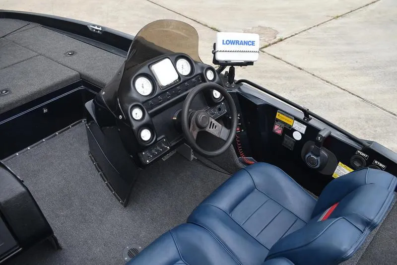 Slide: The Image of 1997 Stratos 282 DC boat cockpit with steering wheel and Lowrance navigation system. - 16