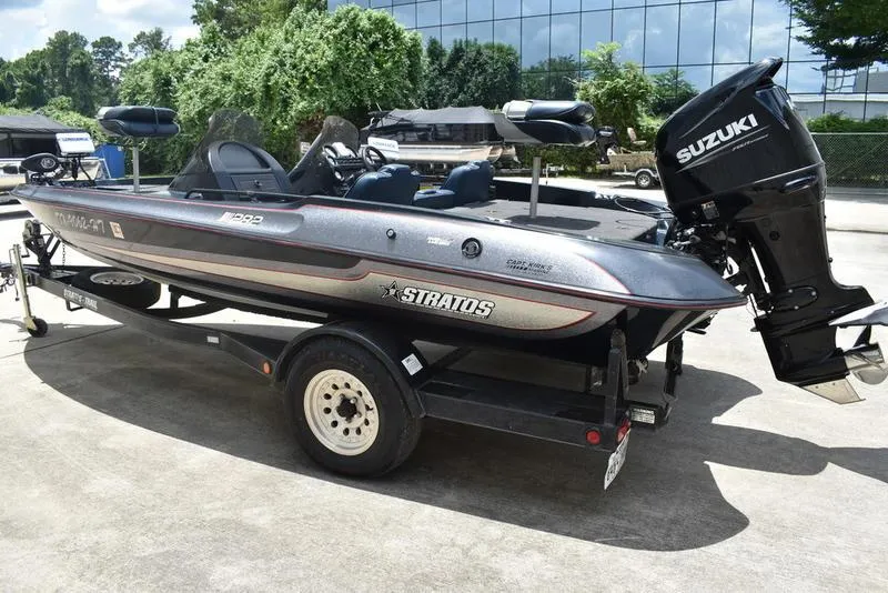 Slide: The Image of 1997 Stratos 282 DC boat with Suzuki motor on trailer, parked outdoors. - 3
