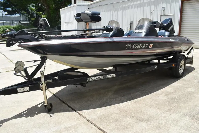 Slide: The Image of 1997 Stratos 282 DC boat on trailer, parked outdoors, featuring MotorGuide trolling motor. - 5