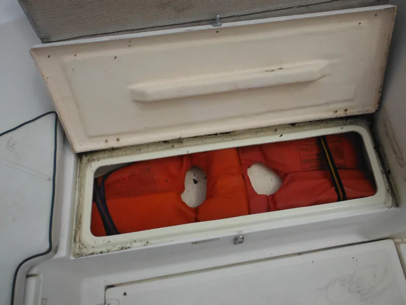 Slide: The Image of Open storage compartment on 1996 Hydra-Sports 2000 DC boat with orange life jackets inside. - 17