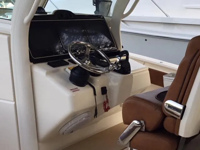 Slide: The Image of Helm of 2016 Scout 350 LXF boat with steering wheel and brown seat. - 10
