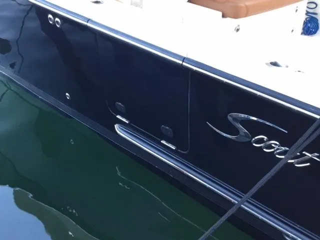 Slide: The Image of 2016 Scout 350 LXF boat side view with logo, docked on calm water. - 11