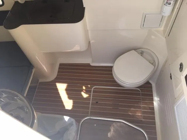 Slide: The Image of 2016 Scout 350 LXF boat interior with toilet and wooden flooring. - 14