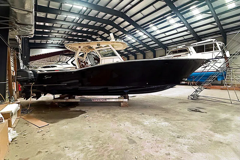 Slide: The Image of 2016 Scout 350 LXF boat in a spacious indoor storage facility. - 32
