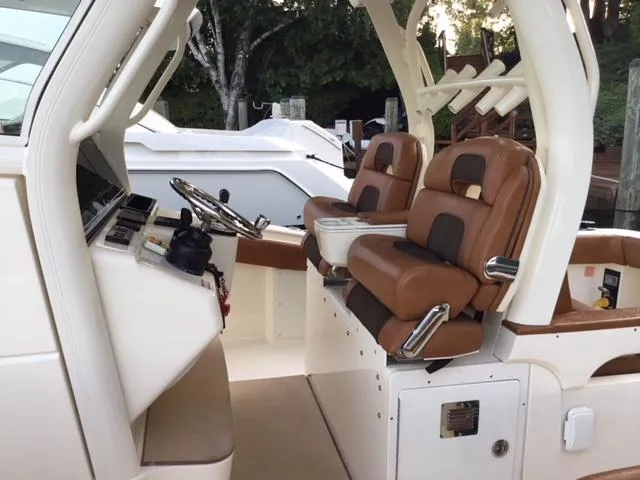 Slide: The Image of 2016 Scout 350 LXF boat interior with brown leather seats and steering console. - 7