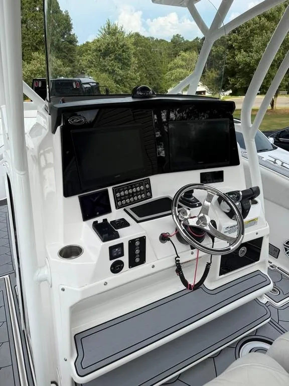 Slide: The Image of 2022 Sea Fox 328 Commander boat dashboard with steering wheel and electronic controls. - 7
