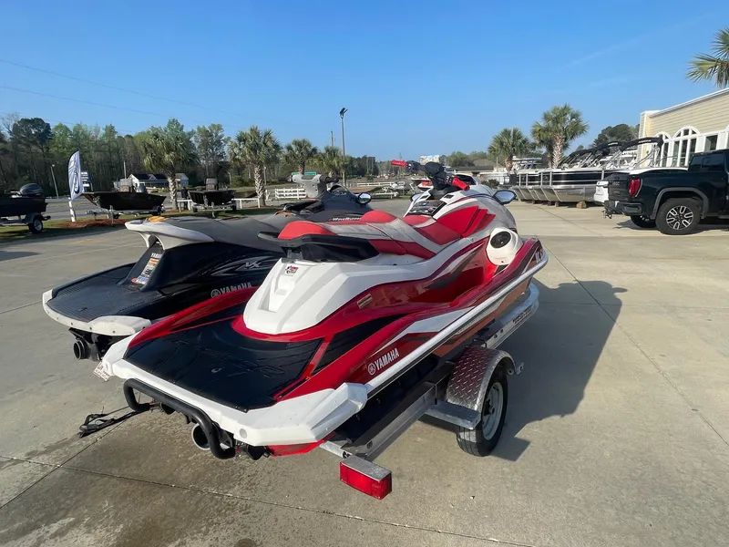 Slide: The Image of 2021 Yamaha WaveRunner GP1800R HO in red and white on a trailer, outdoor setting. - 6