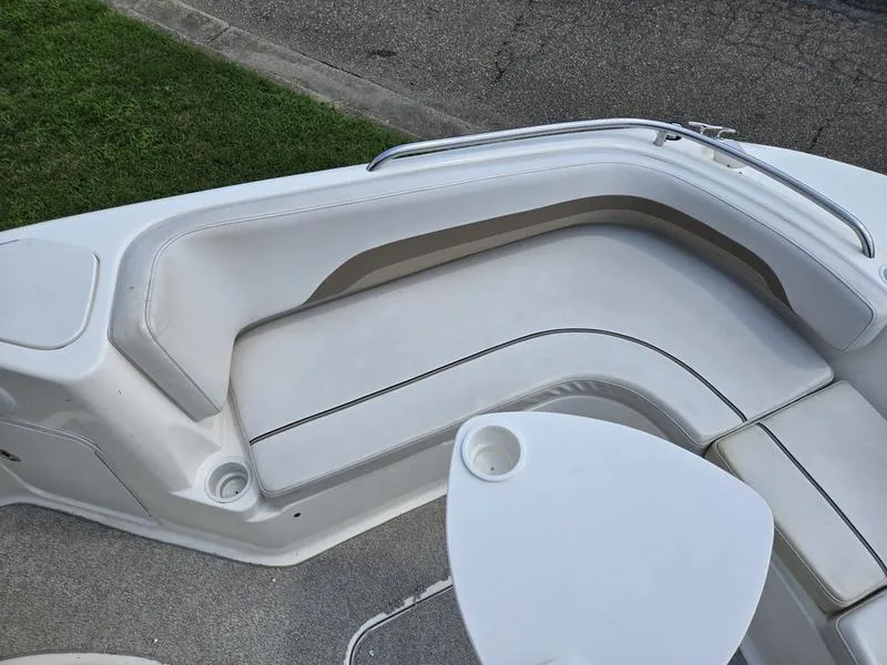 Slide: The Image of 2006 Hurricane GS 211 OB Fun Deck boat interior with white seating and table. - 18