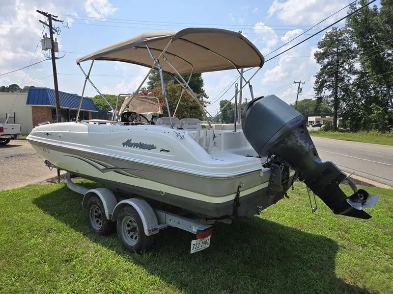 Slide: The Image of 2006 Hurricane GS 211 OB Fun Deck boat on trailer, parked on grass. - 3