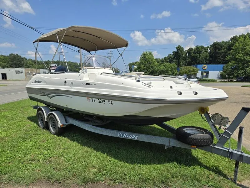 Slide: The Image of 2006 Hurricane GS 211 OB Fun Deck boat on trailer, parked on grass under blue sky. - 4