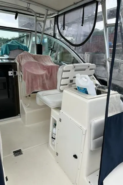 Slide: The Image of 2003 Pursuit 3070 Express boat interior with helm seat and covered seating area. - 12