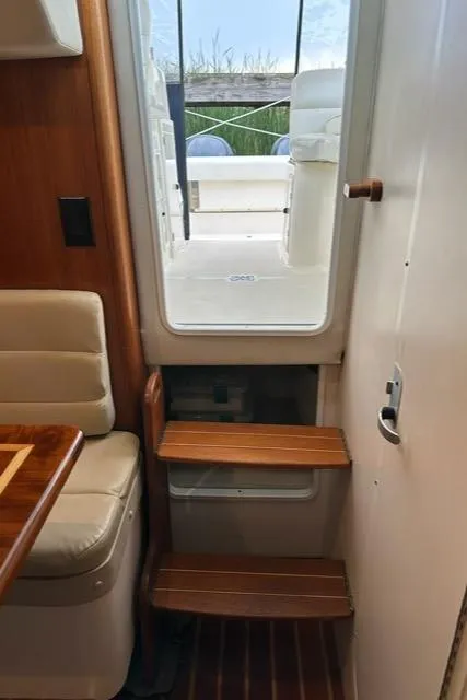 Slide: The Image of Interior view of 2003 Pursuit 3070 Express boat with wooden steps and seating. - 15