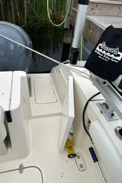Slide: The Image of 2003 Pursuit 3070 Express boat deck with open hatch and fishing equipment. - 17