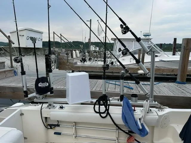 Slide: The Image of 2003 Pursuit 3070 Express boat with fishing rods docked at marina. - 3