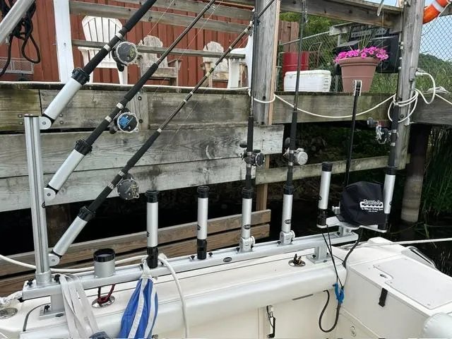 Slide: The Image of Fishing rods on a 2003 Pursuit 3070 Express boat docked near wooden pier. - 5