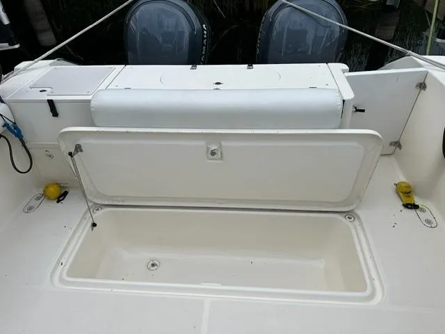 Slide: The Image of 2003 Pursuit 3070 Express boat with open storage compartment and dual outboard motors. - 9