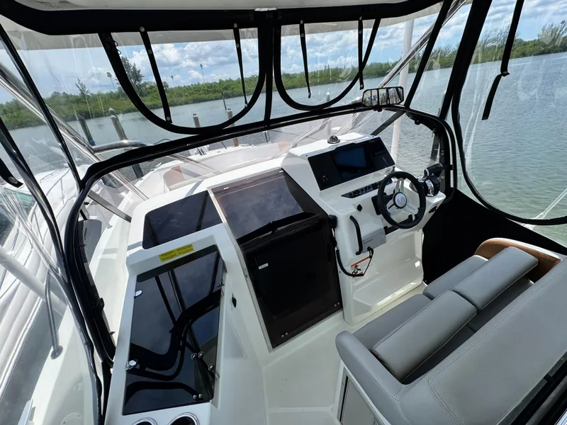 Slide: The Image of 2022 Beneteau Flyer 9 SUNdeck cockpit with modern controls and seating, overlooking serene waters. - 11
