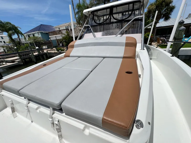 Slide: The Image of 2022 Beneteau Flyer 9 SUNdeck with cushioned sunbathing area, docked near waterfront homes. - 27