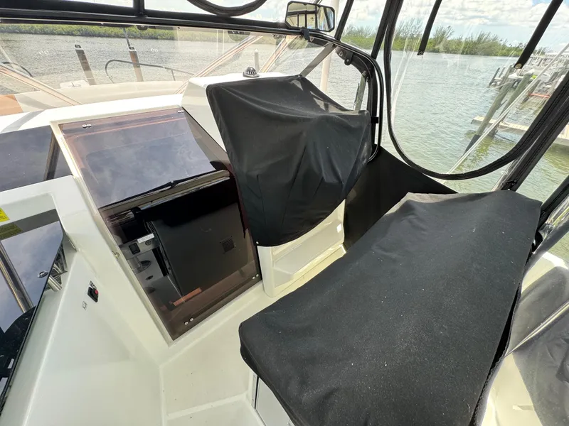 Slide: The Image of 2022 Beneteau Flyer 9 SUNdeck cockpit with covered seating and helm, near water. - 33