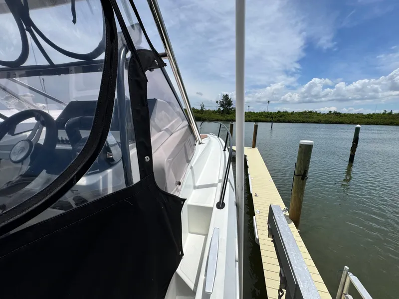 Slide: The Image of 2022 Beneteau Flyer 9 SUNdeck docked, showcasing sleek design and clear canopy. - 35