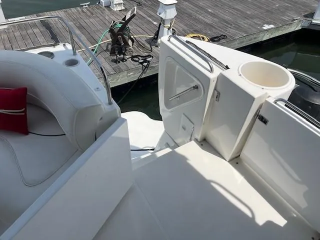 Slide: The Image of 2000 Cruisers Yachts 4450 Express Motoryacht docked, featuring white seating and deck area. - 11