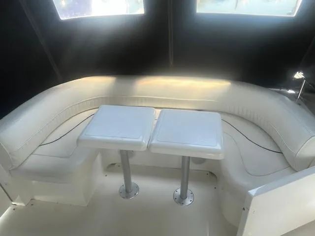 Slide: The Image of 2000 Cruisers Yachts 4450 Express Motoryacht interior with white seating and dual tables. - 14