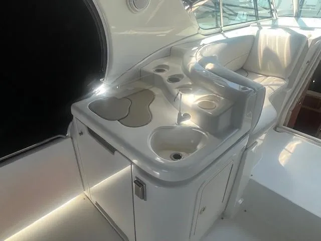 Slide: The Image of 2000 Cruisers Yachts 4450 Express Motoryacht interior with sink and seating area. - 15
