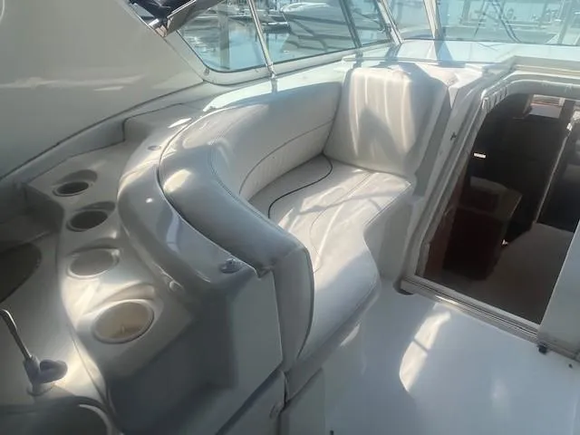 Slide: The Image of 2000 Cruisers Yachts 4450 Express Motoryacht interior with white seating and cup holders. - 19