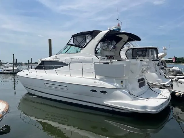 Slide: The Image of 2000 Cruisers Yachts 4450 Express Motoryacht docked in a marina. - 4