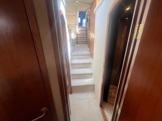 Slide: The Image of Interior hallway of 2000 Cruisers Yachts 4450 Express Motoryacht, featuring wooden doors and carpeted stairs. - 45