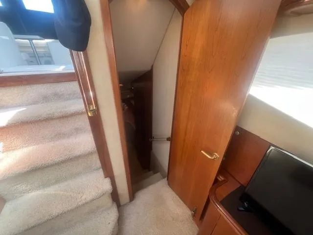 Slide: The Image of Interior view of 2000 Cruisers Yachts 4450 Express Motoryacht, featuring stairs and wooden cabinetry. - 46
