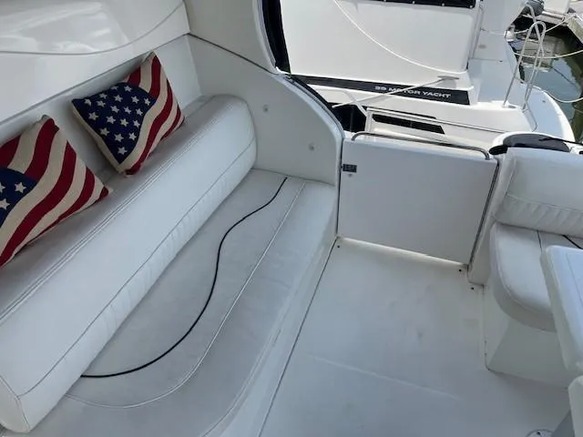 Slide: The Image of Luxurious 2000 Cruisers Yachts 4450 Express Motoryacht interior with white seating and decorative pillows. - 9