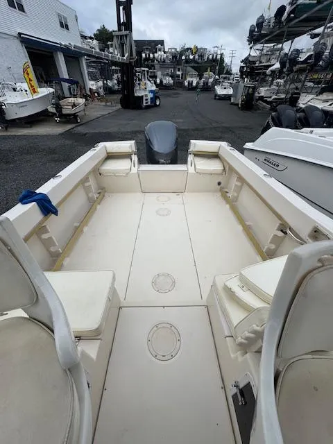 Slide: The Image of 1992 Grady-White Explorer 244 boat interior at a marina, showcasing spacious deck layout. - 12