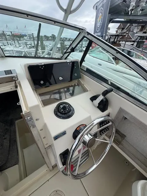 Slide: The Image of 1992 Grady-White Explorer 244 boat helm with steering wheel and control panel. - 13