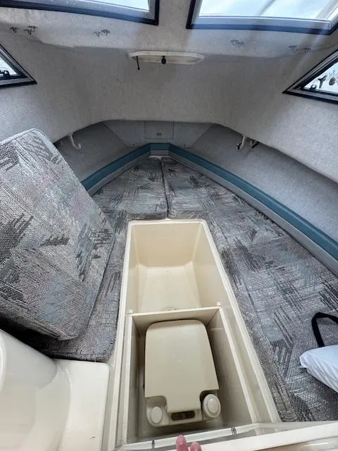 Slide: The Image of 1992 Grady-White Explorer 244 cabin interior with patterned cushions and storage compartment. - 14
