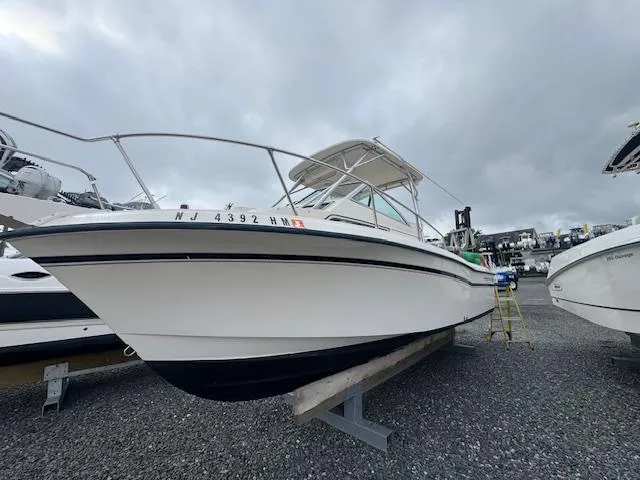 Slide: The Image of 1992 Grady-White Explorer 244 boat on gravel, overcast sky background. - 21