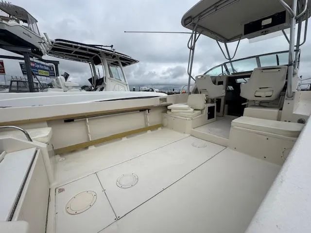 Slide: The Image of 1992 Grady-White Explorer 244 boat interior with spacious seating and helm, under cloudy skies. - 24